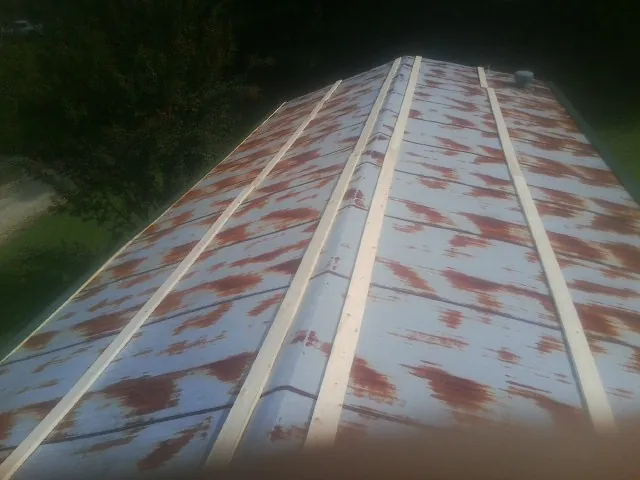 Rusted metal roof panels with new wood purlins before replacement — Storm Damage Roof Repair in Thaxton by Roofing Brothers