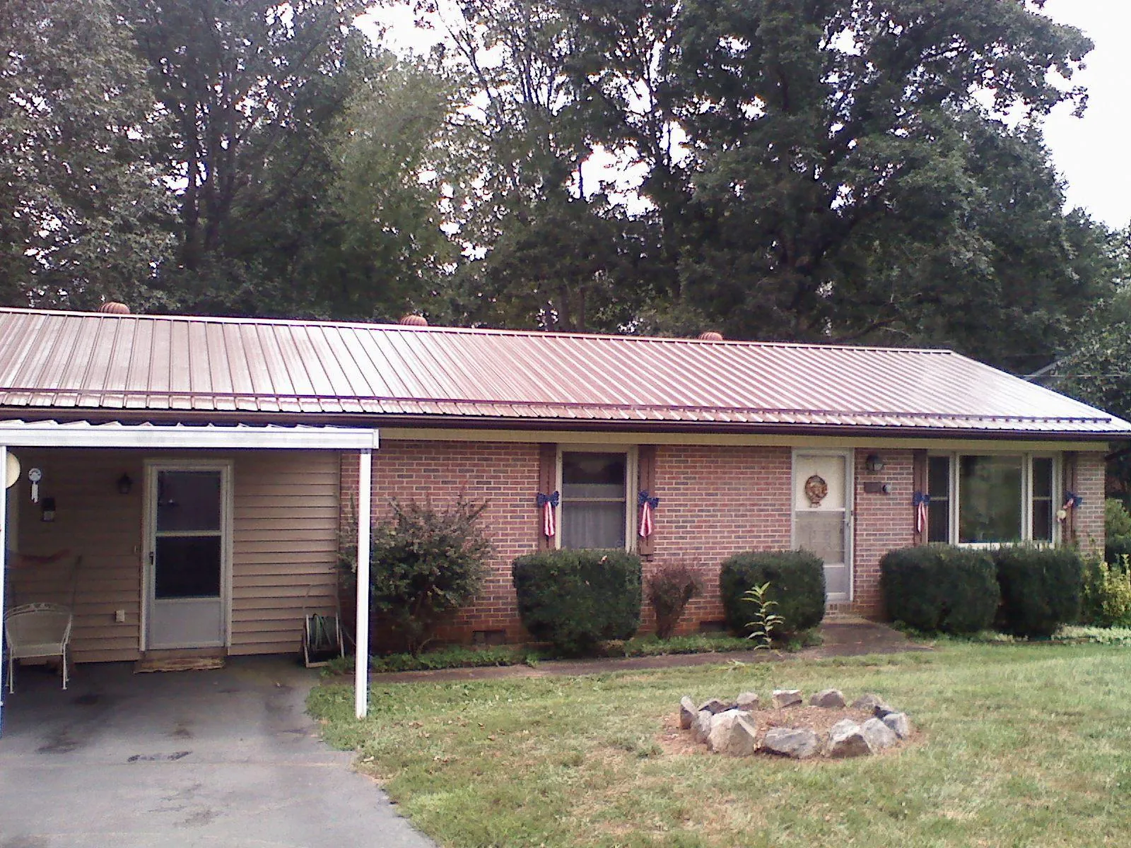 Bronze metal roof and carport on a brick ranch home — Roof Repair work by our crew in Thaxton
